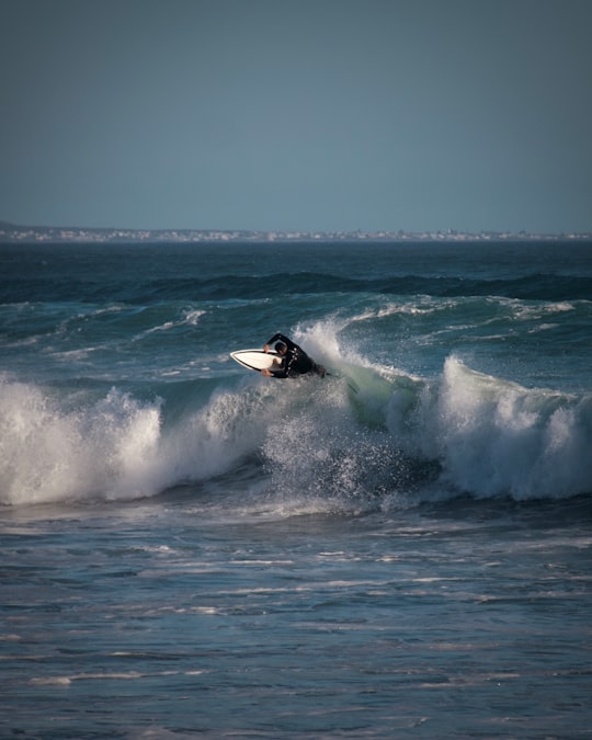 person surfing on sea waves during daytime in Hermanus South Africa