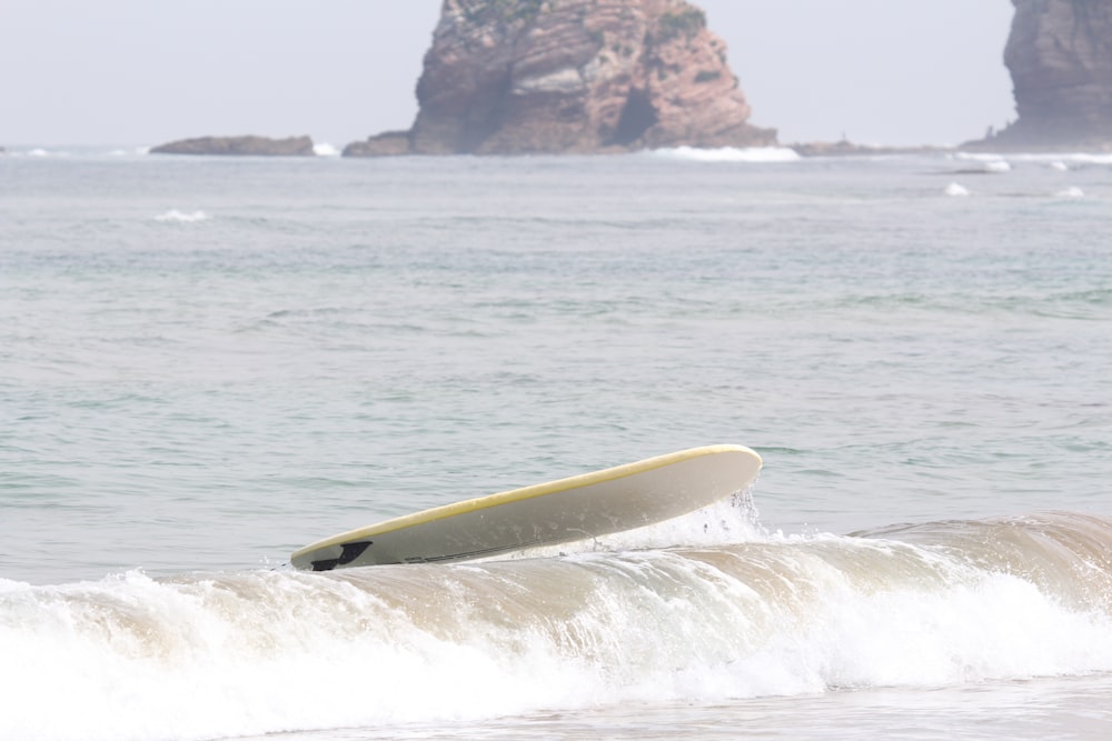 yellow surfboard on sea during daytime