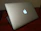 Man unboxing a sleek laptop at a bright kitchen table
