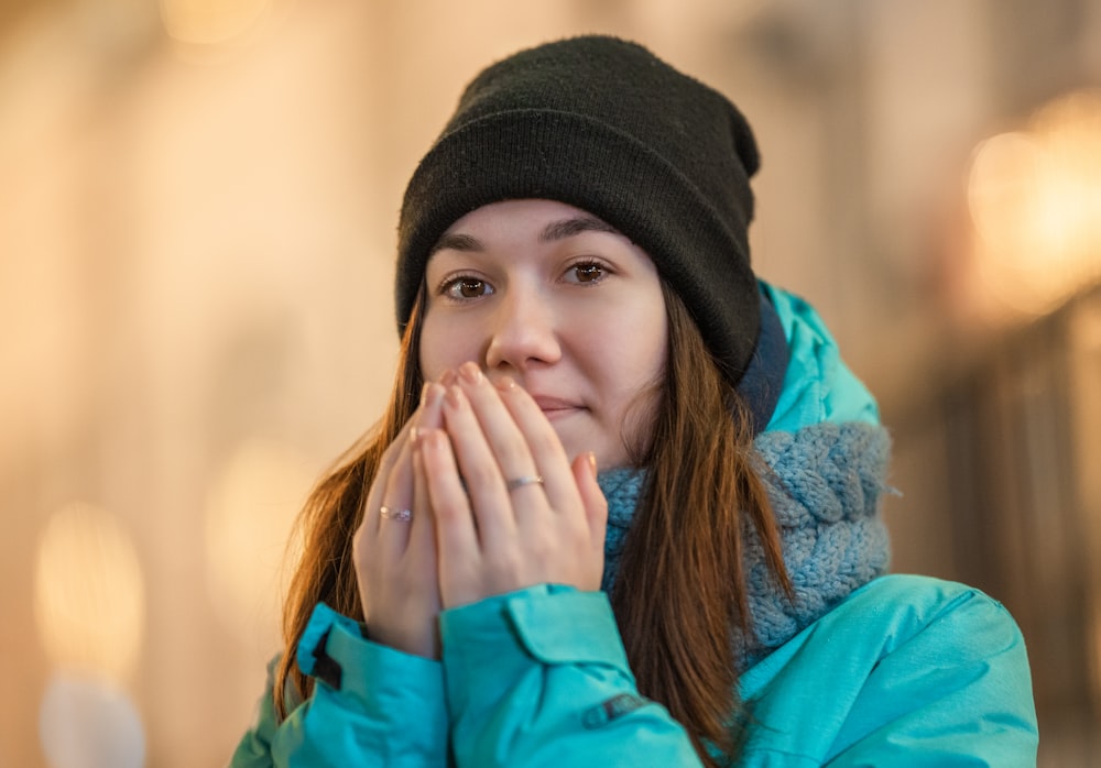 woman in blue jacket wearing black knit cap