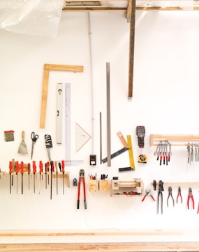 assorted hand tools on white table