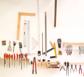 assorted hand tools on white table