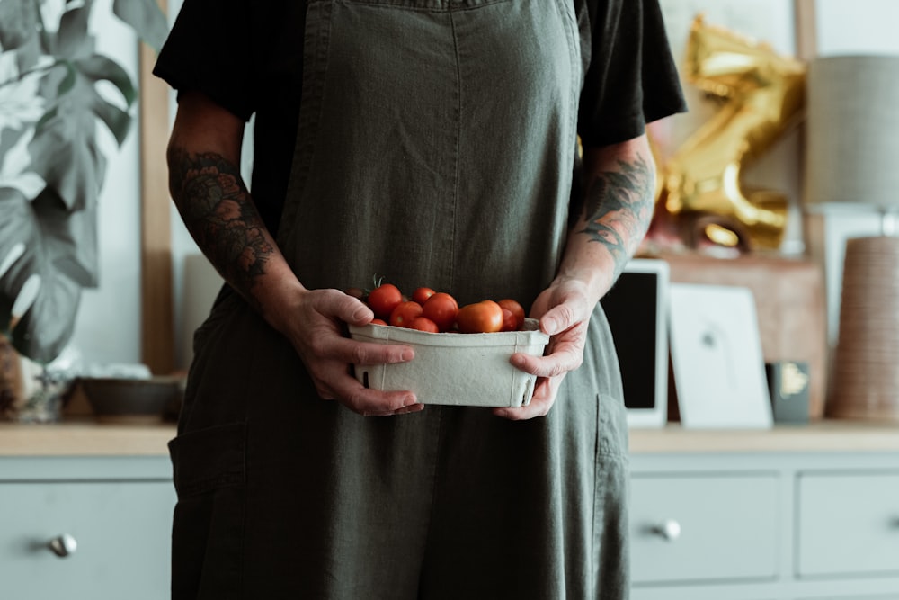 woman in black v neck shirt holding orange fruit