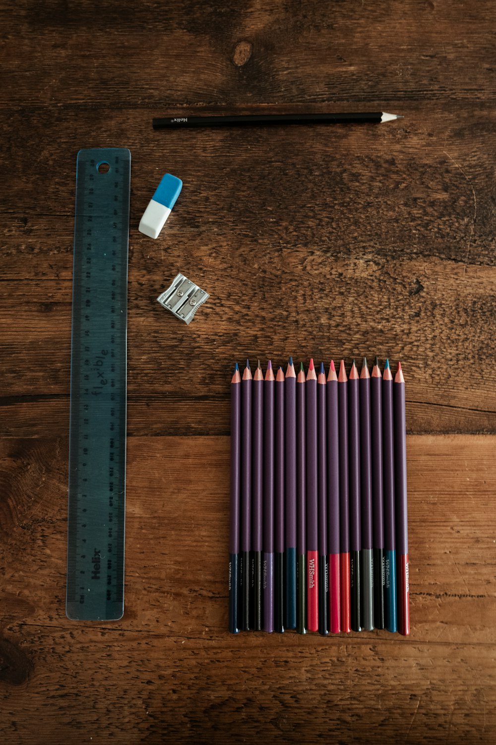 blaue und weiße Bleistifte auf braunem Holztisch