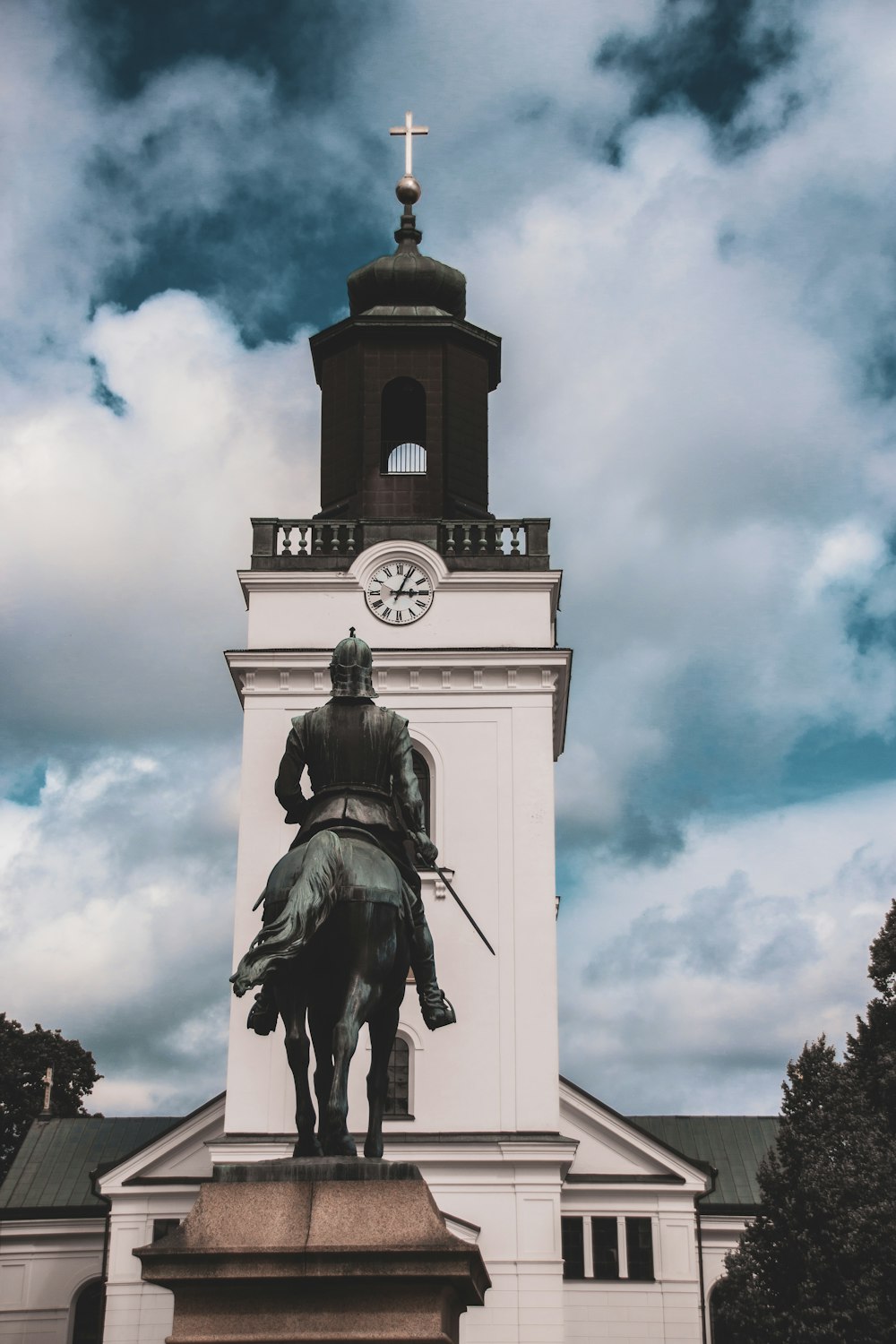 hombre montando estatua de caballo bajo el cielo nublado durante el día