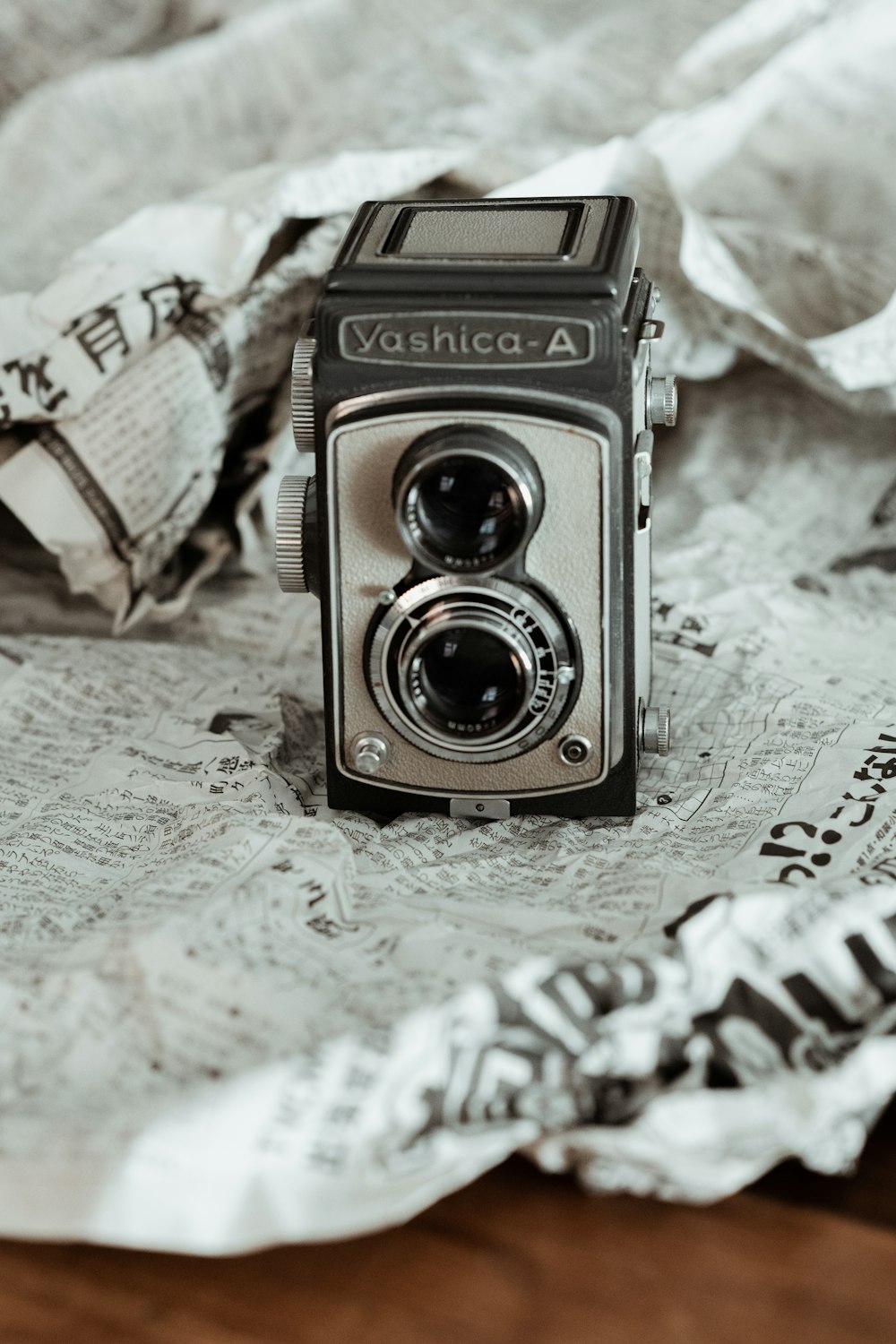 black and silver camera on white textile