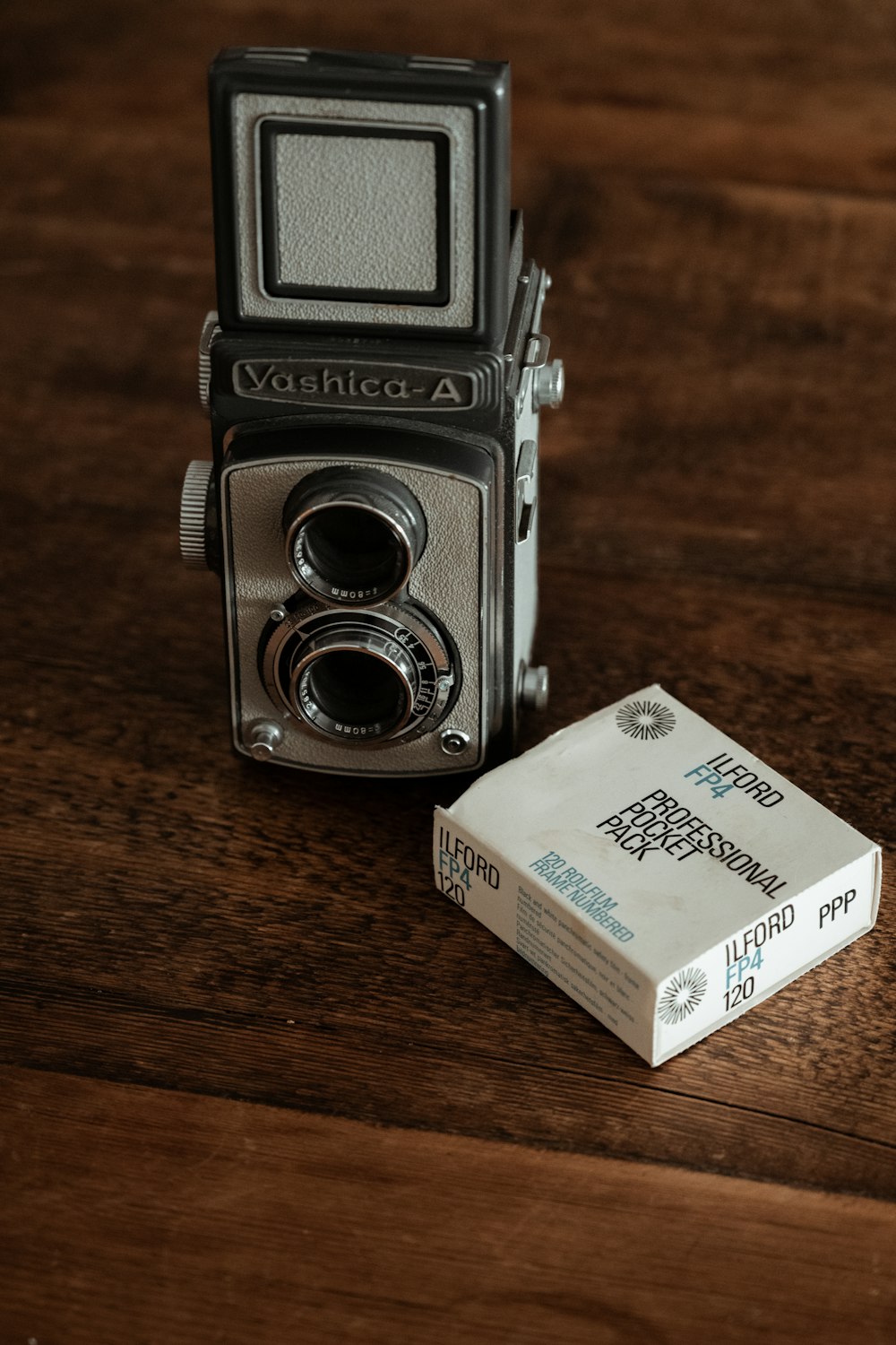 schwarz-silberne Kamera auf braunem Holztisch
