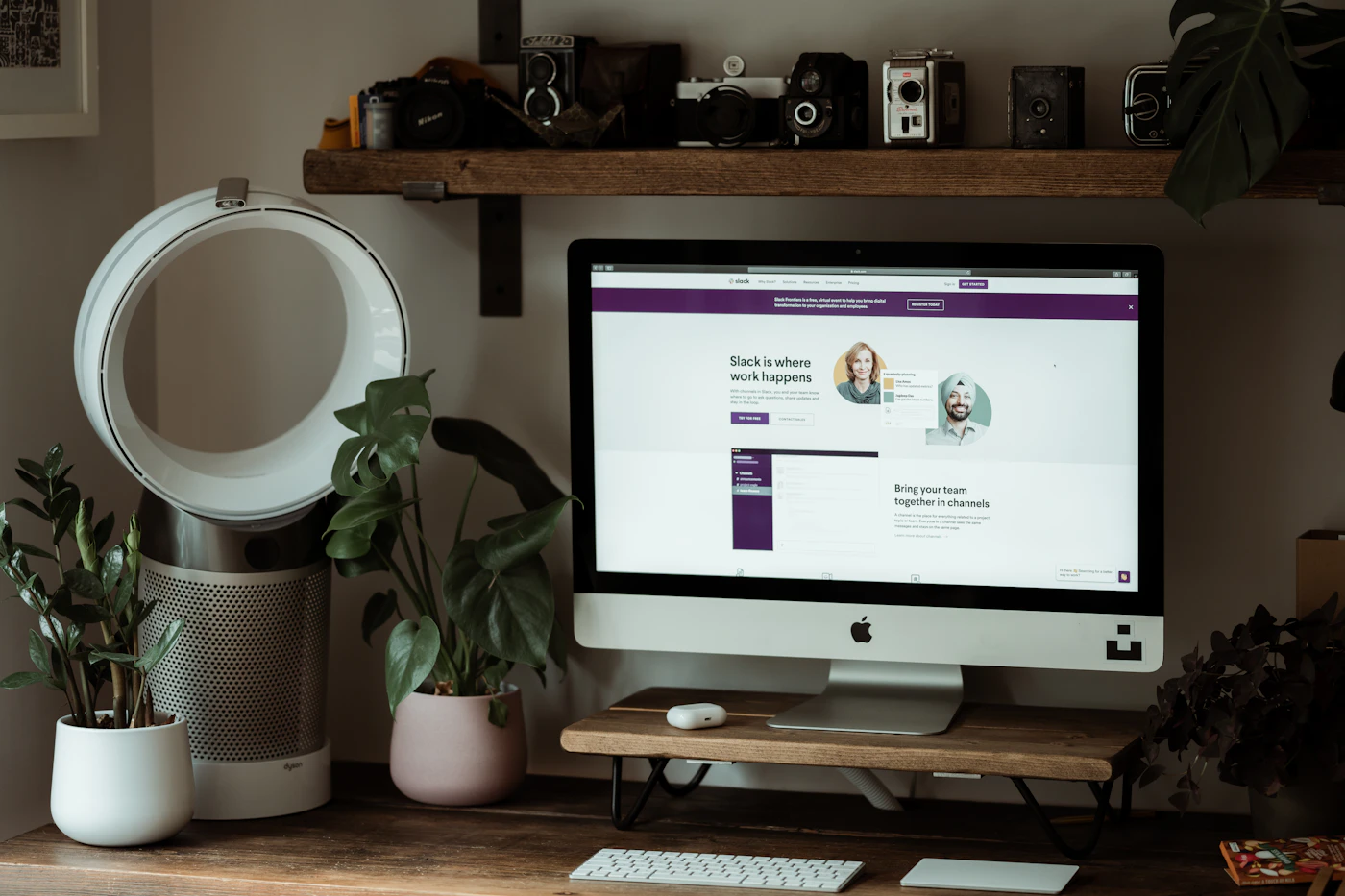 Silver iMac on a brown wooden table in a workspace
