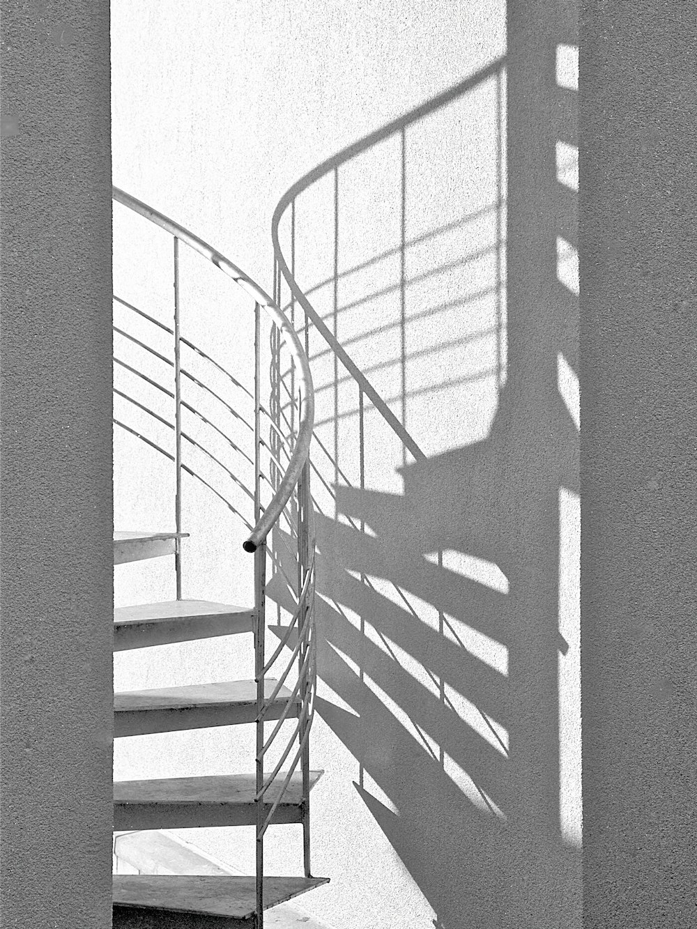 Escalera de caracol blanca con barandillas metálicas negras