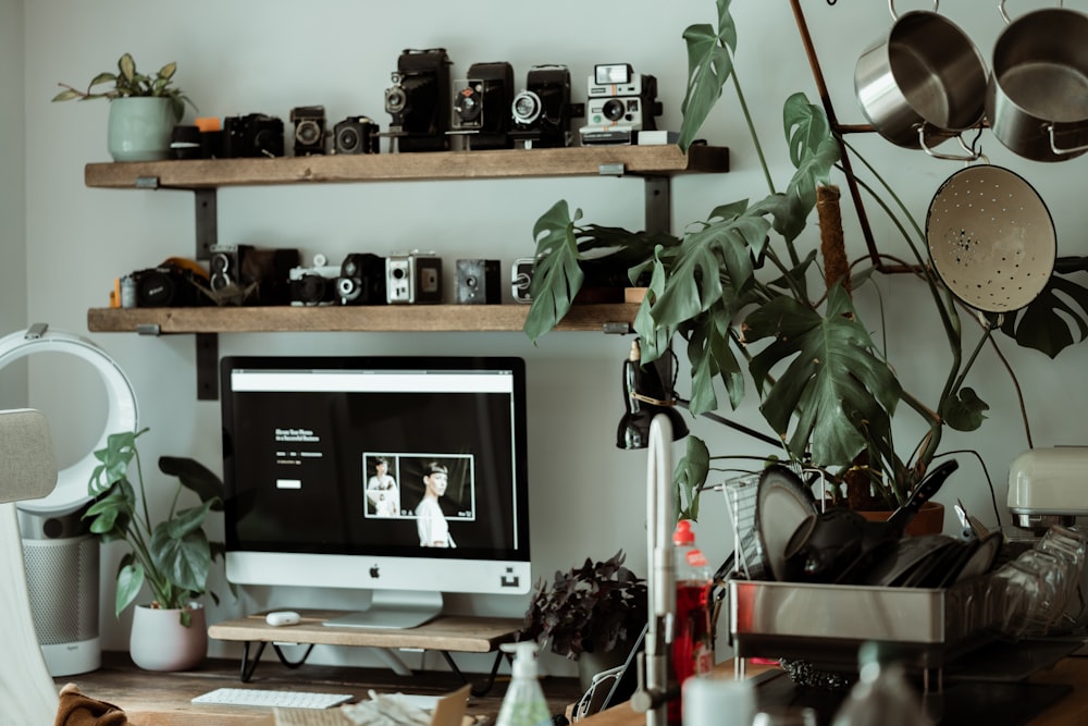 silver imac on brown wooden shelf