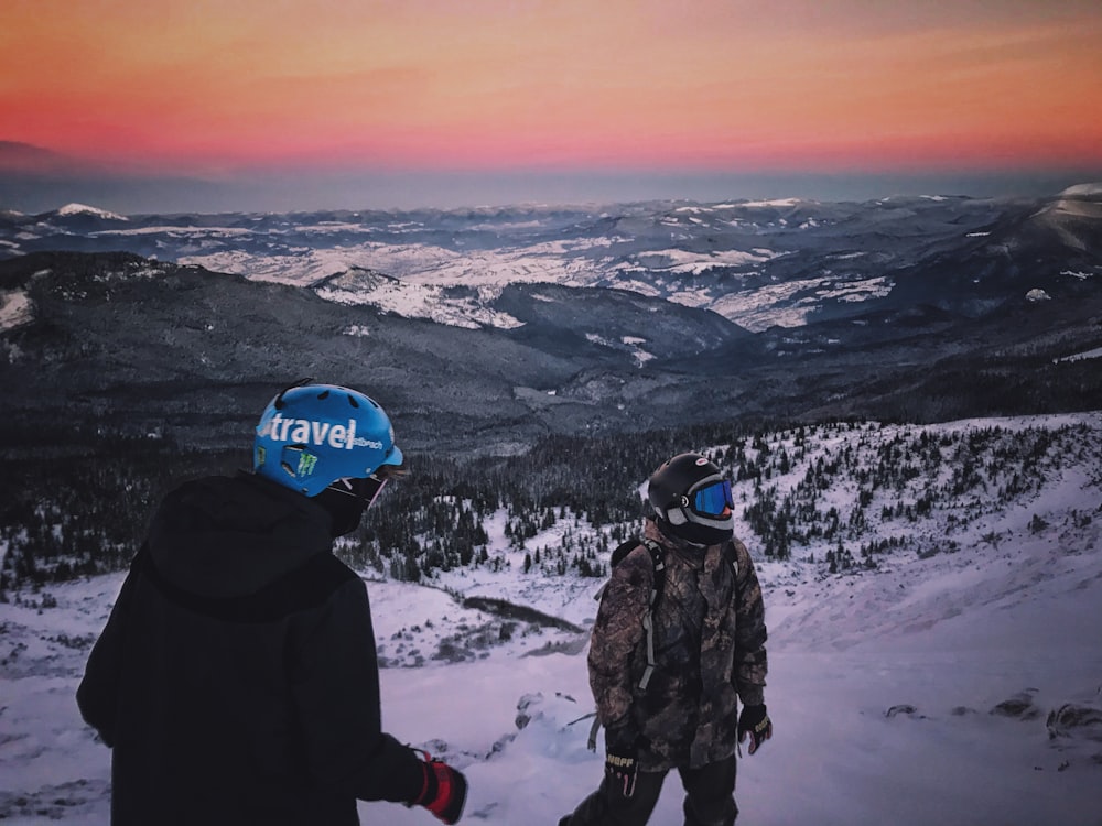 2 person wearing black winter jacket standing on snow covered ground during daytime