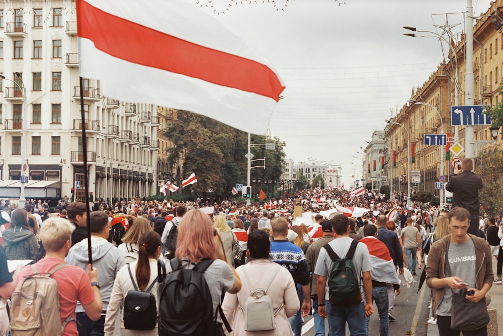 people walking on street with flags during daytime