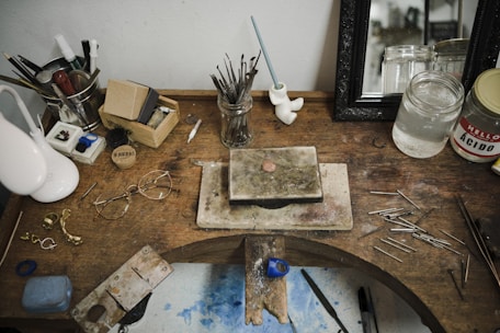 An antique jeweler’s workbench with brass tools and a magnifying glass resting on aged parchment.