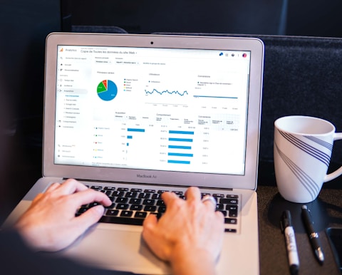 person using macbook pro on black table