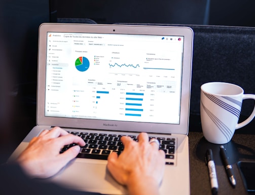 person using macbook pro on black table