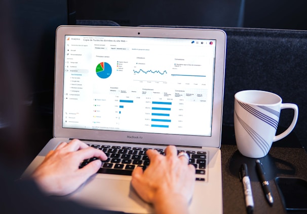 person using macbook pro on black table