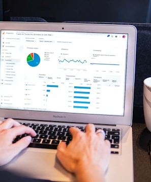 person using macbook pro on black table