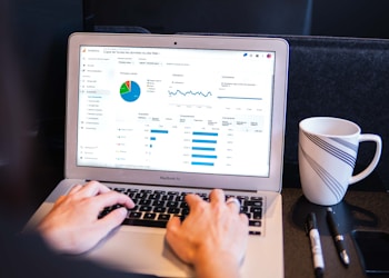 person using macbook pro on black table