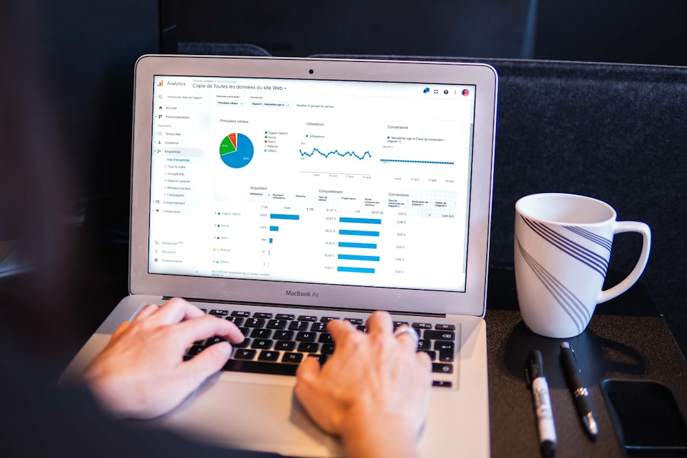 person using macbook pro on black table