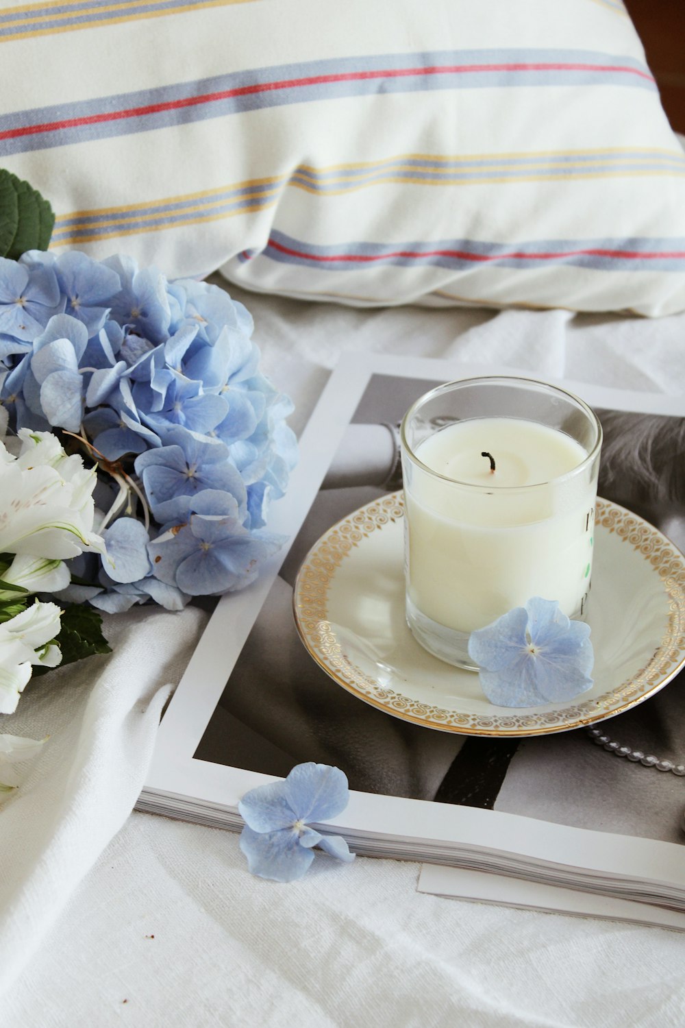 white candle on blue and white floral ceramic saucer