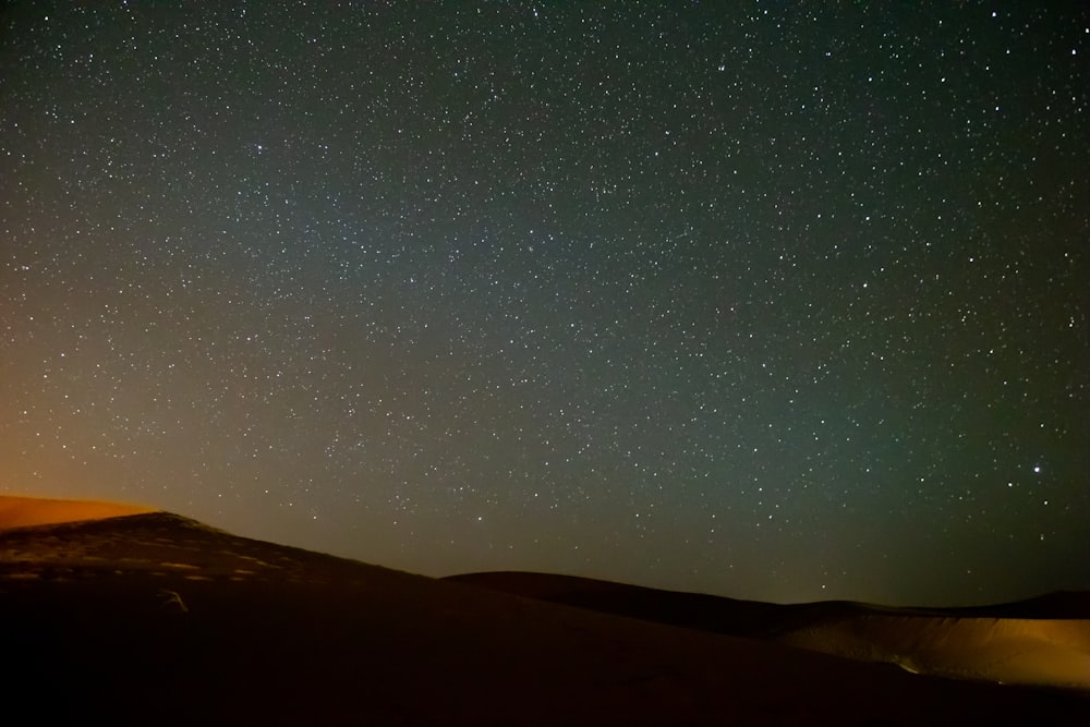 silhouette of mountain under starry night