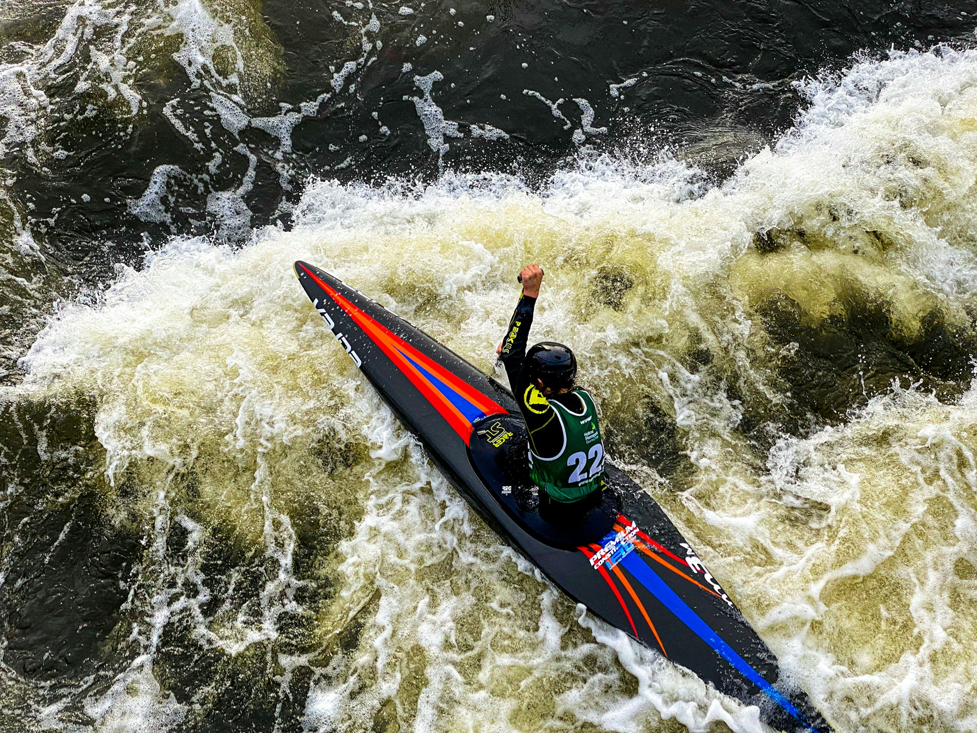 man in blue and red suit riding on blue and red kayak