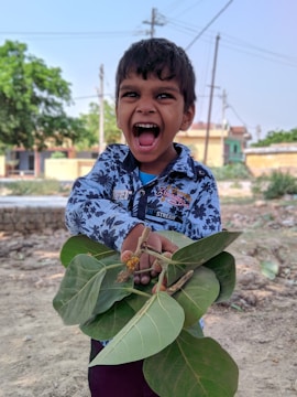 A joyful child holding a basket overflowing with colorful fresh fruits.
