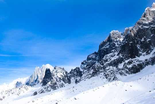 snow covered mountain under blue sky during daytime in Mont Blanc du Tacul France