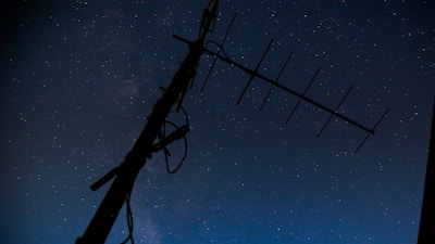 A sleek satellite model against a starry night sky backdrop.