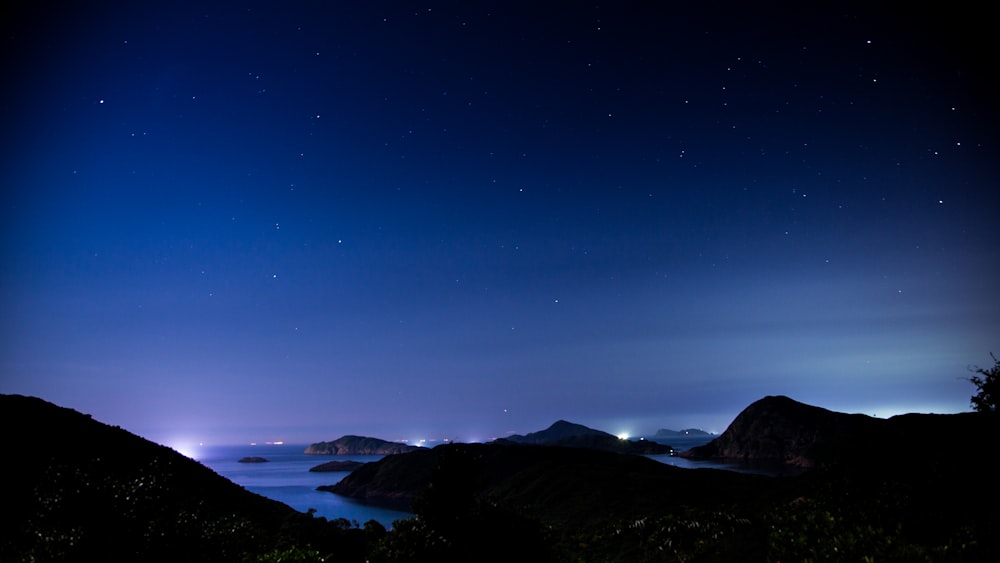 silhouette of mountains during night time