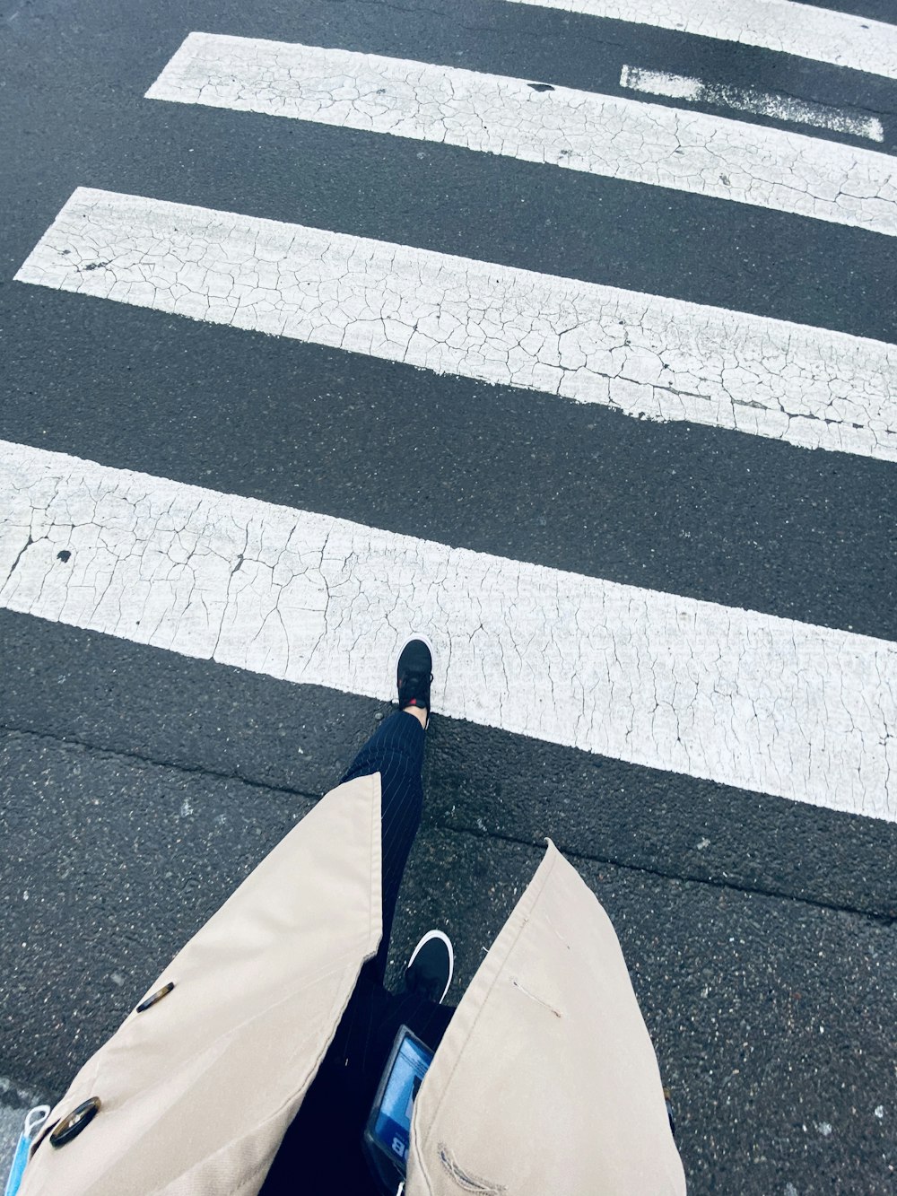 Persona con chaqueta azul caminando por el carril peatonal durante el día