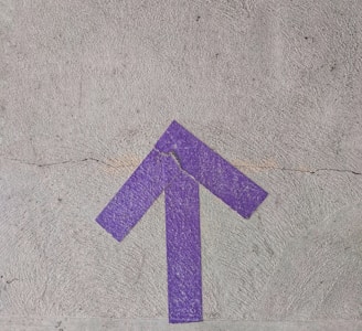 purple and white arrow sign