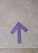 purple and white arrow sign