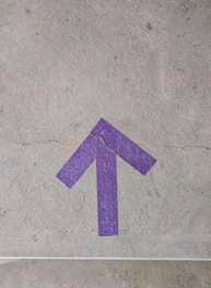 purple and white arrow sign