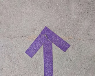 purple and white arrow sign