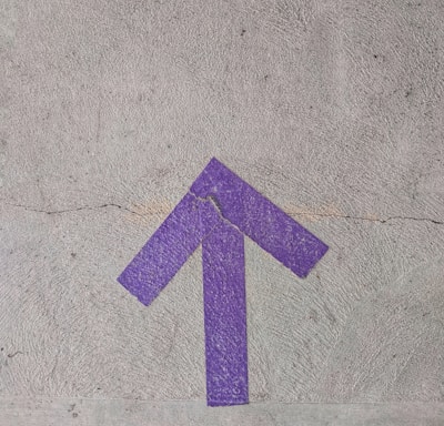 purple and white arrow sign