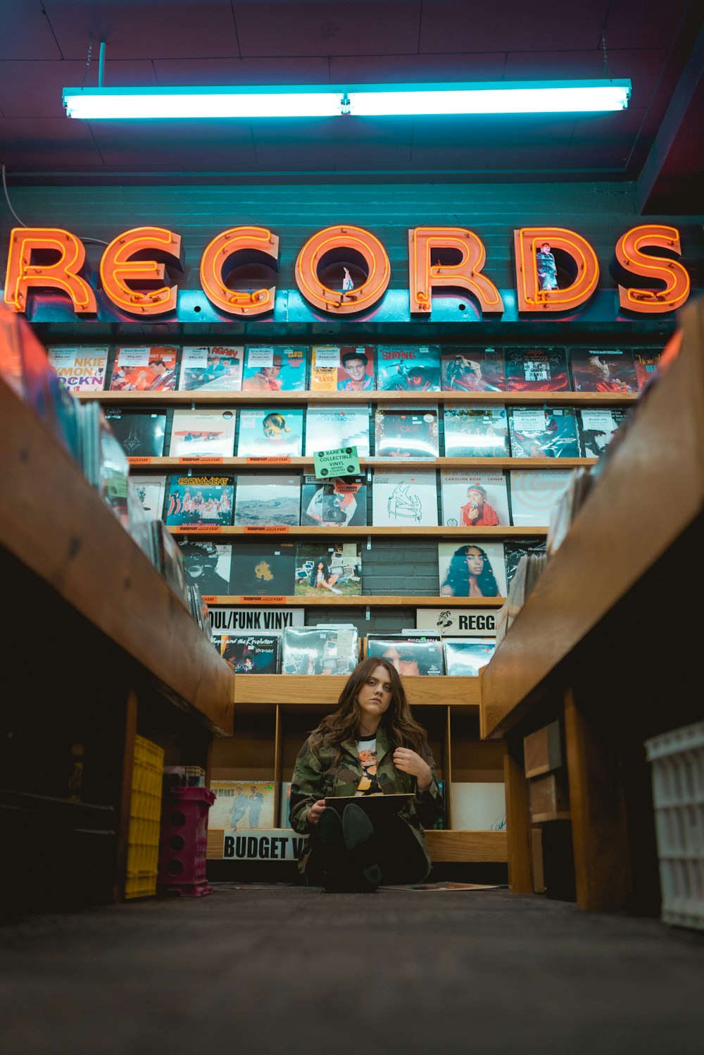 woman in black jacket standing near brown wooden shelf