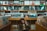 A person is browsing through vinyl records in a music store. The shelves are filled with a variety of record covers categorized by genres such as 'Soul/Funk Vinyl' and 'Reggae.' The ambiance is retro and nostalgic, with colorful album art visible on the shelves.