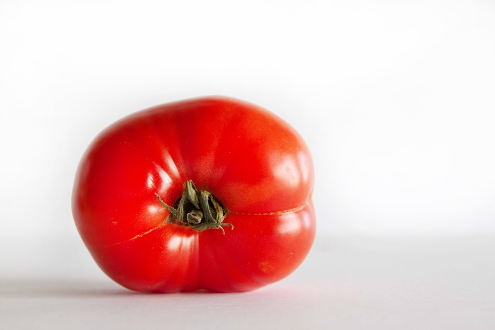 red tomato on white surface