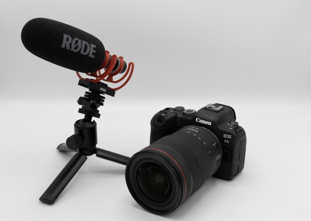 A Canon EOS R6 camera paired with a RØDE microphone is mounted on a compact tripod. The setup likely indicates use for video or audio recording purposes.