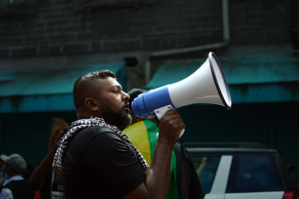 man in black shirt holding blue microphone