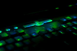 Close-up of glowing cyberpunk keyboard with purple and green lights