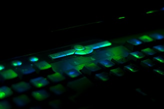 Close-up of a glowing neon keyboard with purple and cyan lights in a dark room.