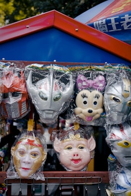 Traditional carnival masks displayed on a colorful market stall.