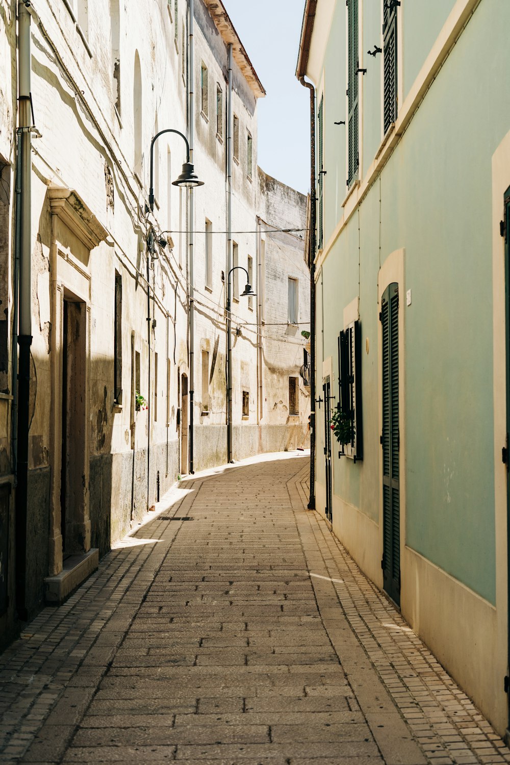 empty street between concrete buildings during daytime