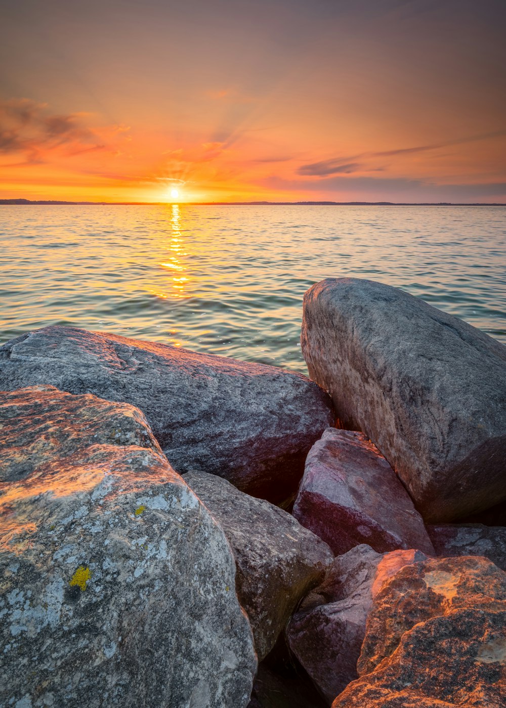 gray and brown rock formation near body of water during sunset