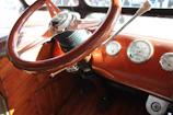 Detail of a vintage car’s dashboard with polished wood and classic gauges.