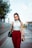 woman in white tank top and red shorts holding black leather handbag