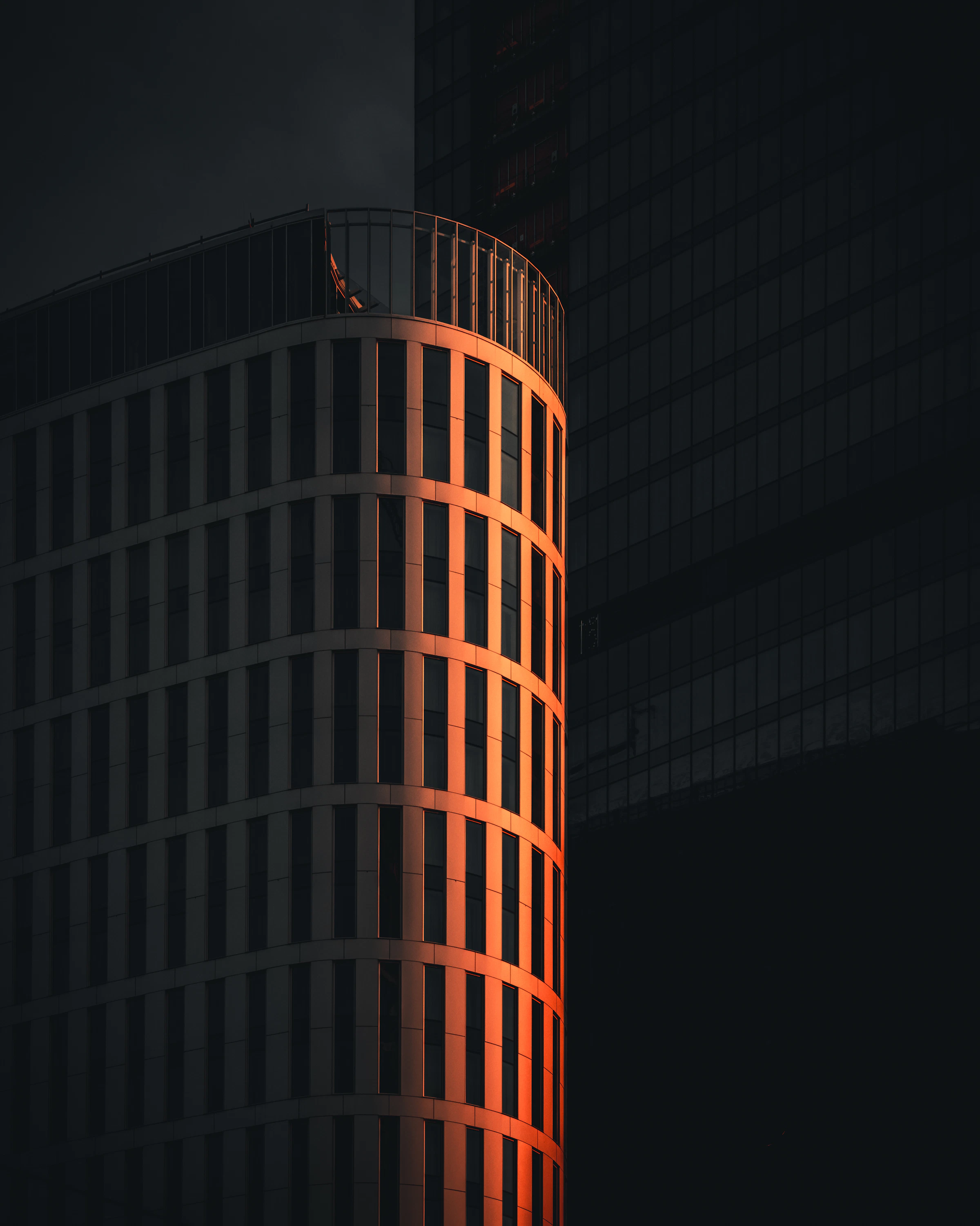 Contemporary Warsaw hotel tower illuminated at sunset