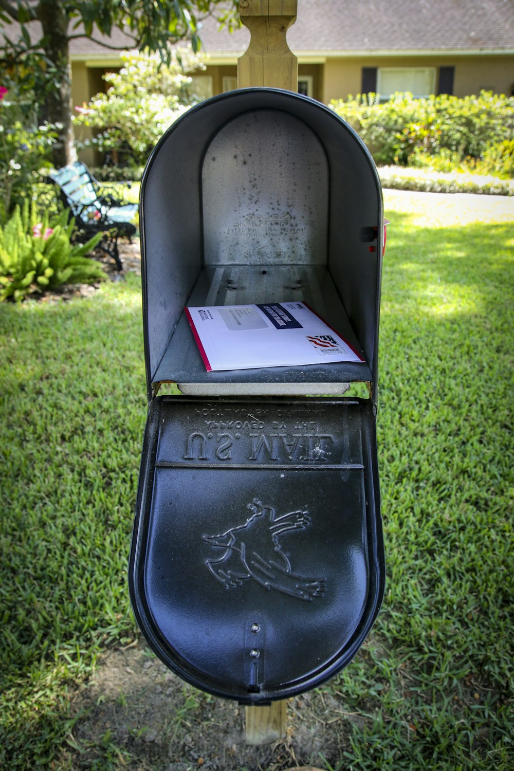 Boîte aux lettres bleue et blanche sur le champ d’herbe verte